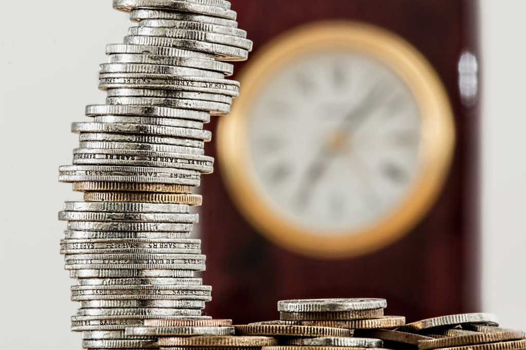 Hiring tech writers from Essential Data saves money, shown by a large stack of coins