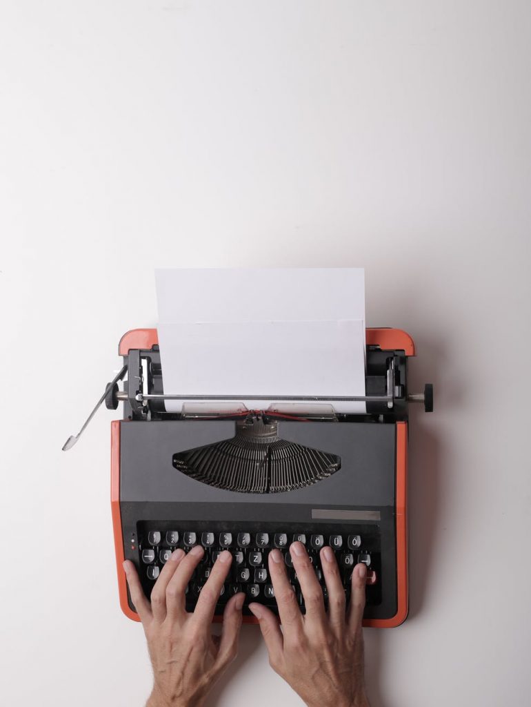 hands sitting on a typewriter, representing the job of technical writers