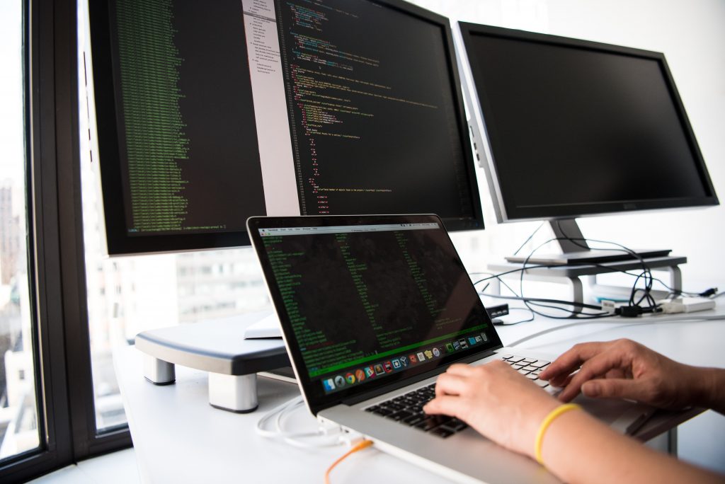 hands at a computer, representing the role of cybersecurity technical writers in protecting company data