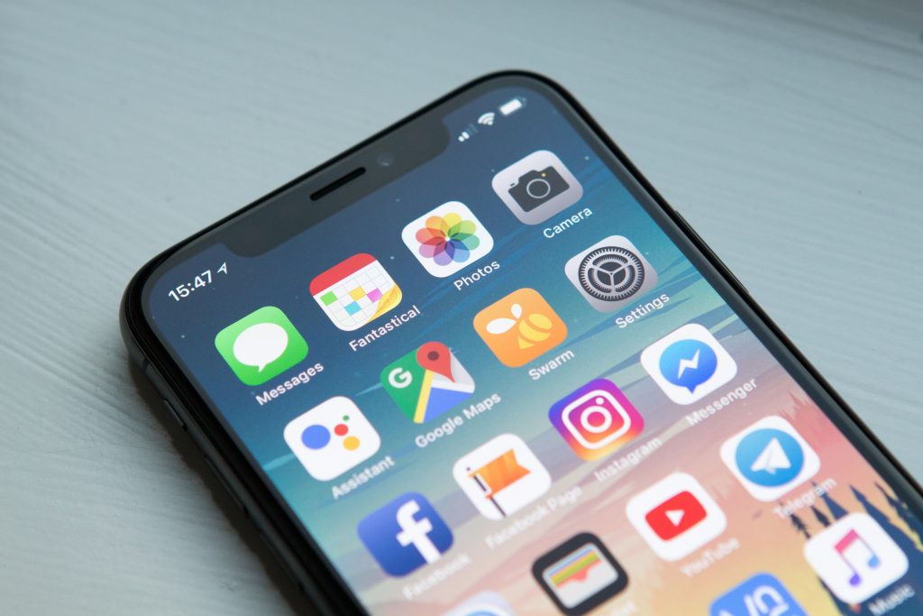 A semi close up view of an iphone x home screen 