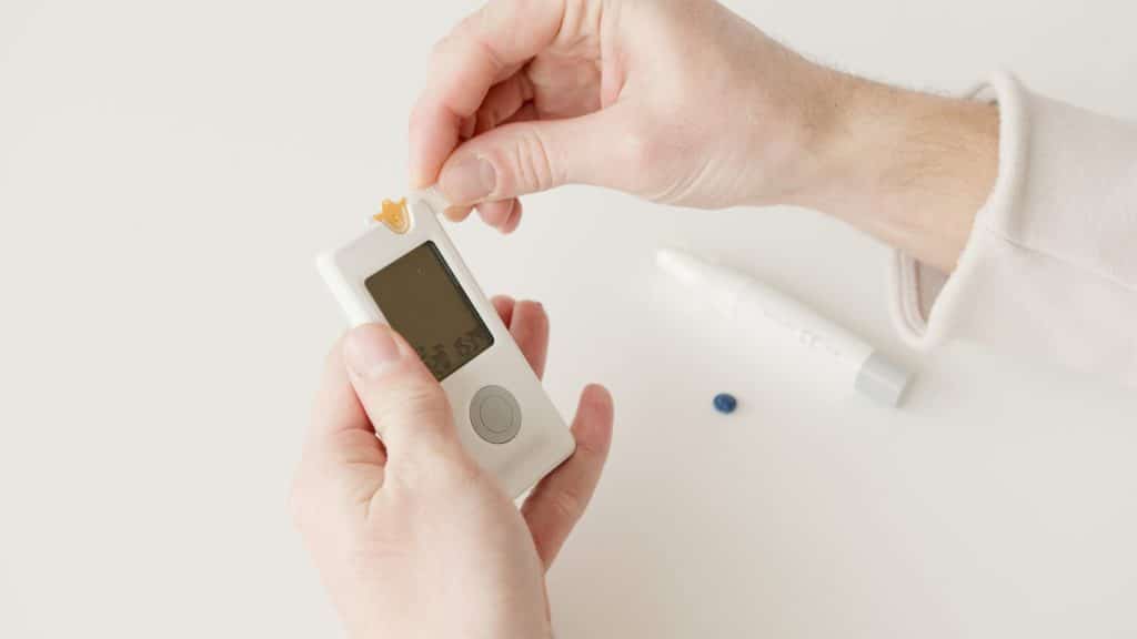 A person using a blood glucose meter to check their blood sugar