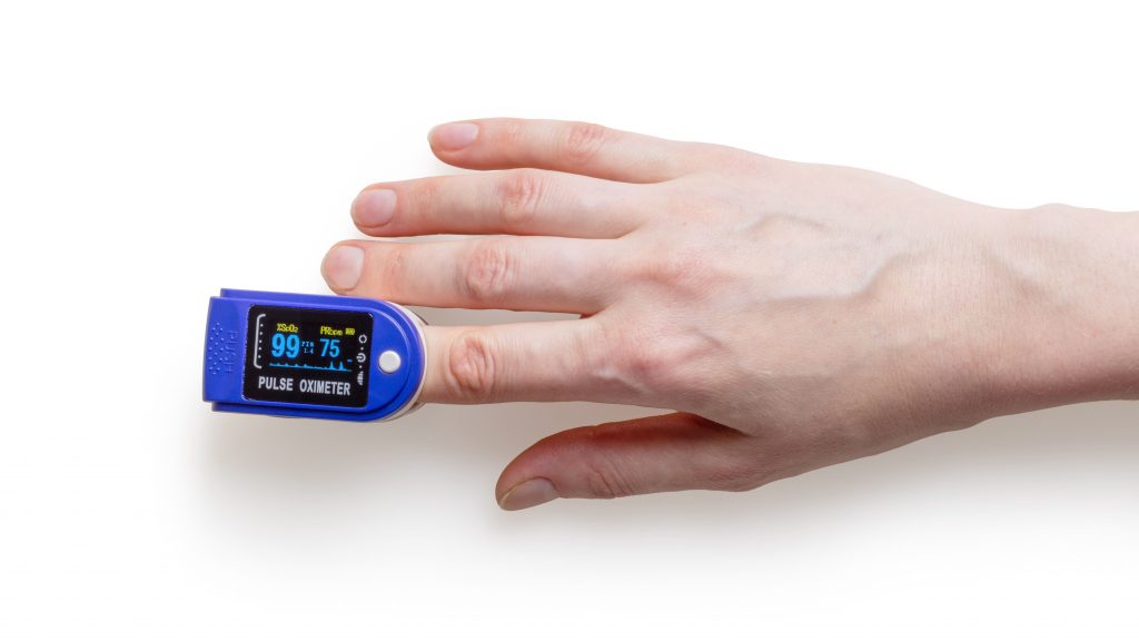 A person using an oximeter on their index finger