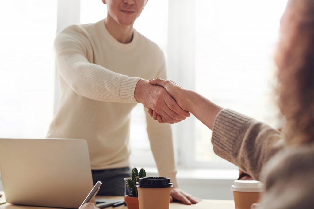 Two people shaking hands at an office 
